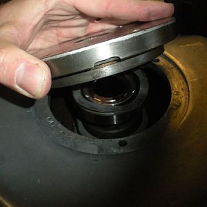 Place the bearing cap over the bearing and the wavy spring washer.