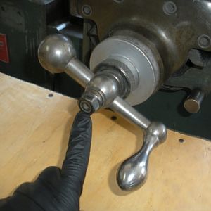 We are starting with the left side table feed handle. Remove this nut first.