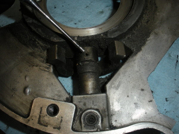 "Mostly" drive out the roll pin in the brake shaft with a punch and hammer, This is holding the brake operating cam to the shaft.