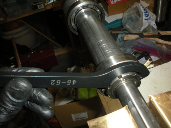 Use the hook spanner and the dead blow hammer to loosen the spindle locking nut.