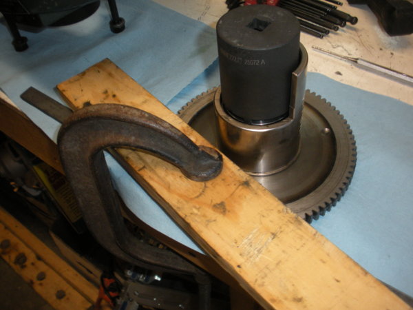 You'll have to hold the bull gear in a way that allows you to tighten the lock nut. I clamped down with a c-clamp and a chunk of wood to the bench.